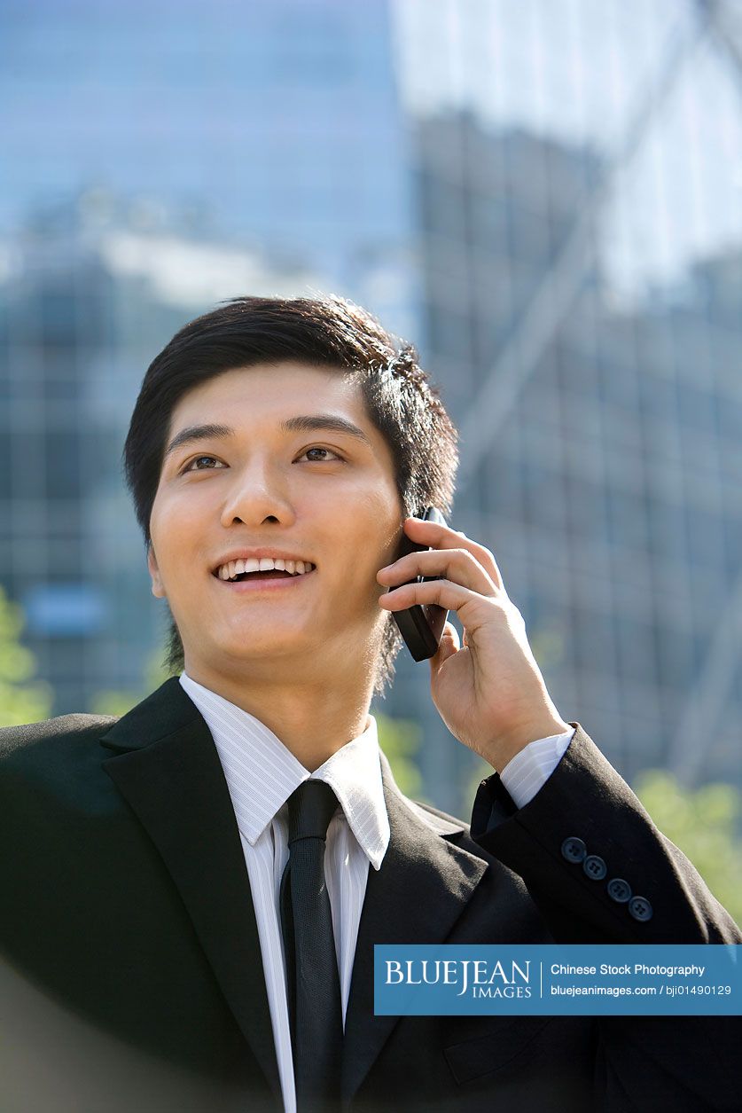 Young Chinese businessman using cellphone