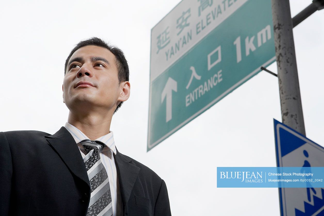 Chinese businessman standing in city fog