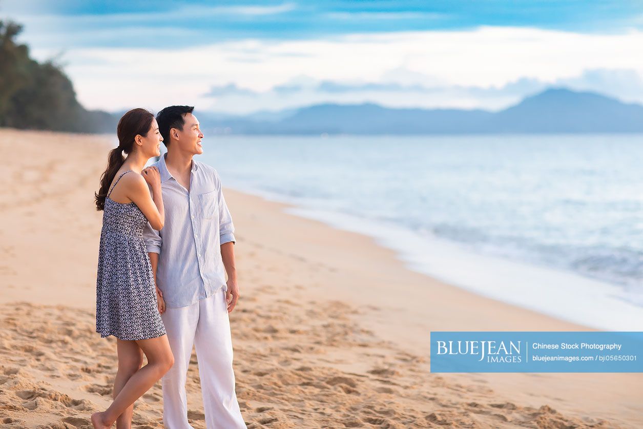 Happy young Chinese couple on beach