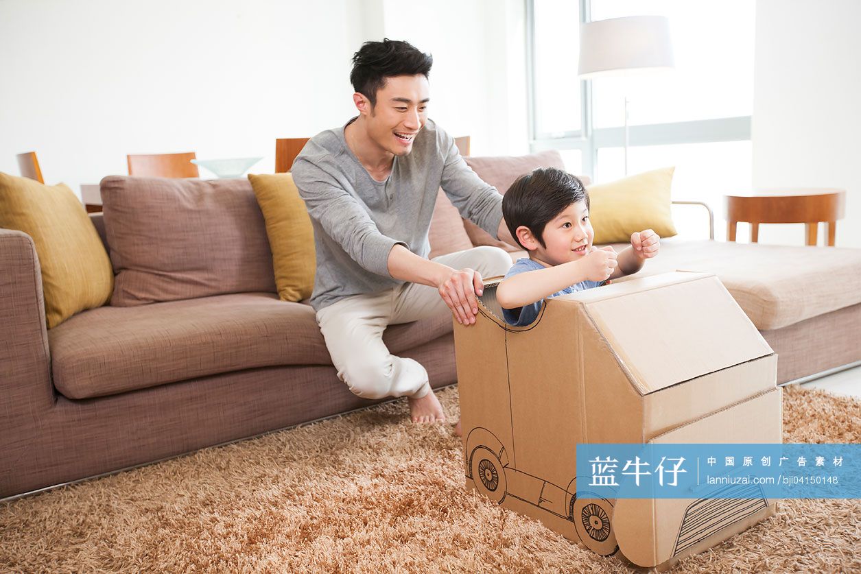 父子俩在客厅里面玩纸箱做的车子