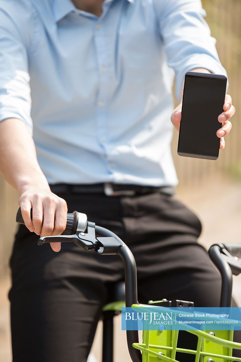 Young Chinese man riding a share bike