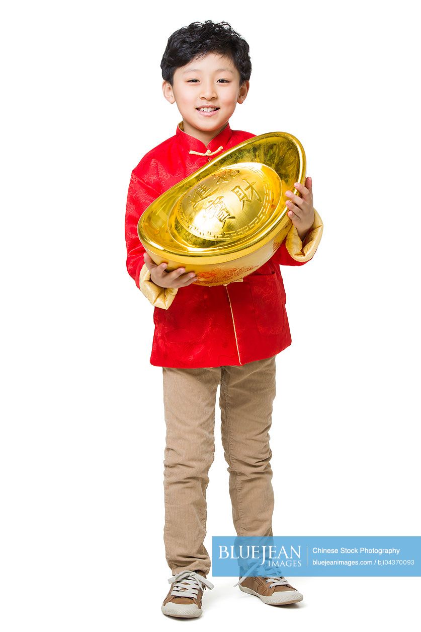 Happy boy holding a large Chinese traditional currency yuanbao