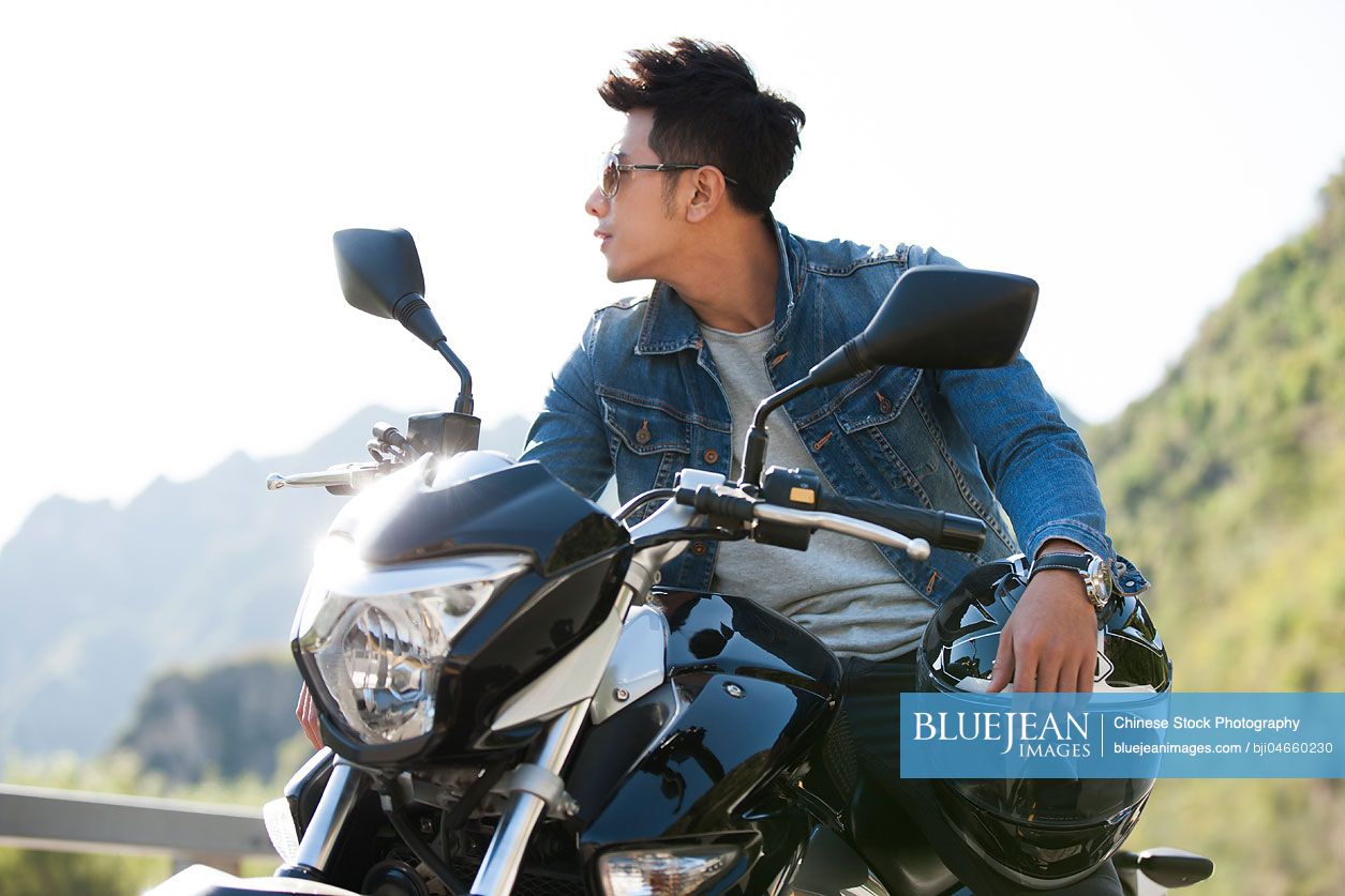 Young Chinese man riding motorcycle