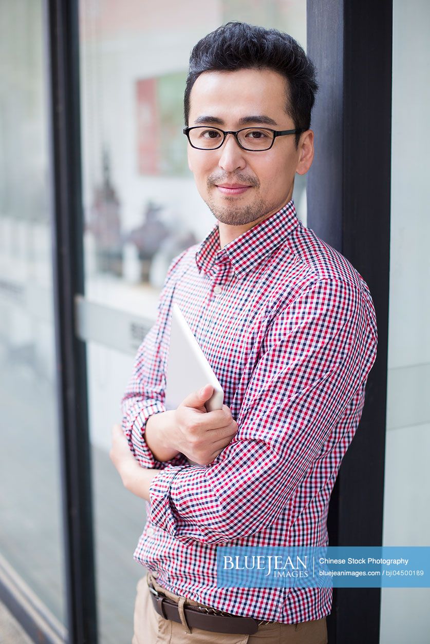 Chinese man holding a digital tablet