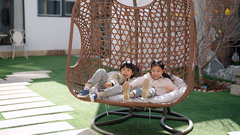 Happy little Chinese children relaxing on hanging-chair,4K