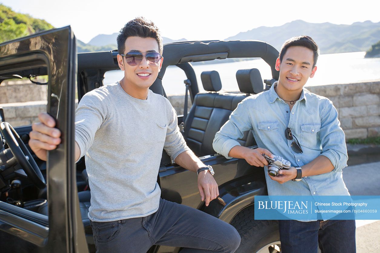 Happy young Chinese men and jeep