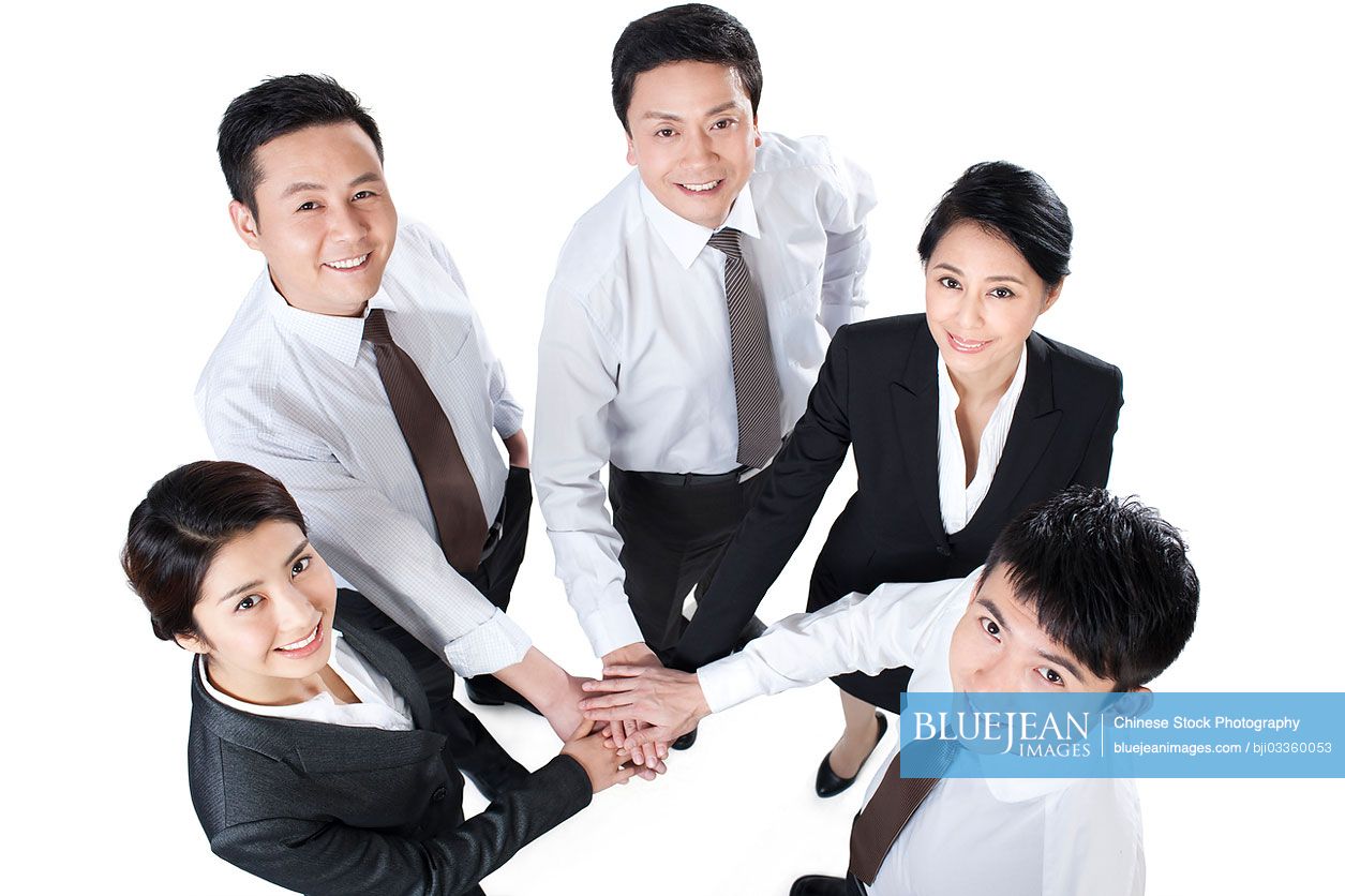 Happy Chinese business persons hands together in a circle