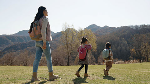 Happy young Chinese family hiking outdoors