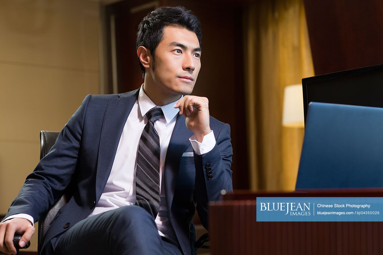 Successful Chinese businessman sitting in study