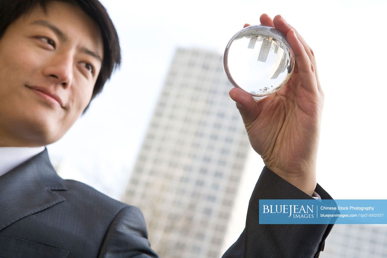 Chinese Businessman Holding Crystal Ball High res Stock Photo For Download chinese-businessman-holding-crystal-ball-high-res-stock-photo-for-download