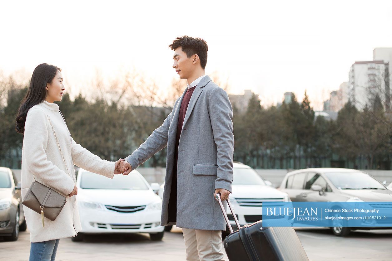 Young Chinese woman's boyfriend leaving for business travel