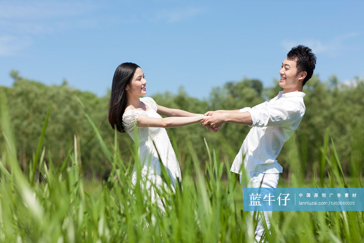 在草地上相拥的情侣-蓝牛仔影像-中国原创广告影像素材