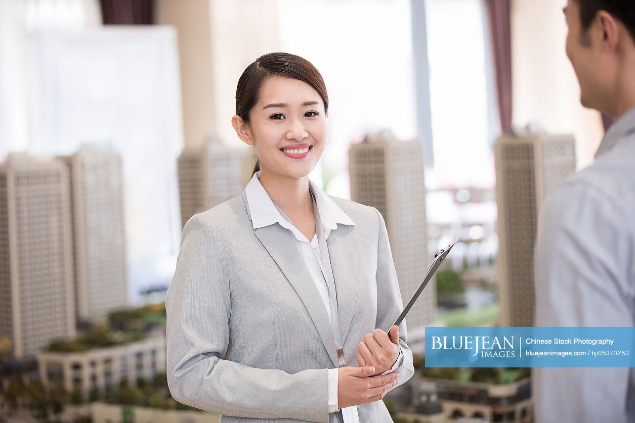 Confident Chinese realtor in sales center-High-res stock photo for download