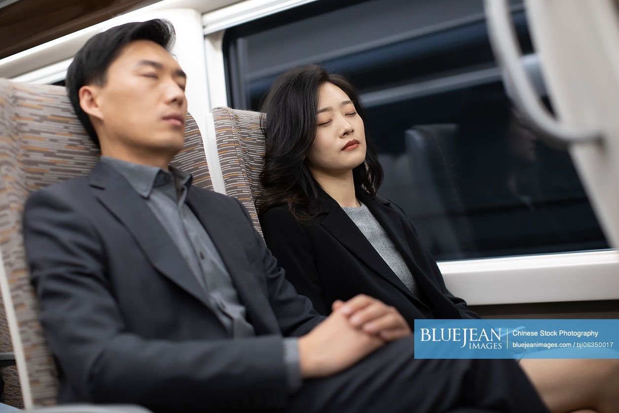 Successful Chinese business people resting on high-speed train