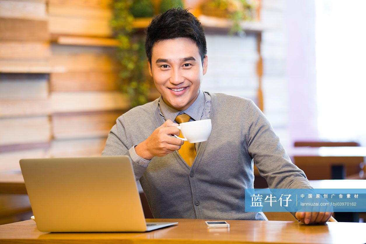 年轻男子在咖啡店喝咖啡上网