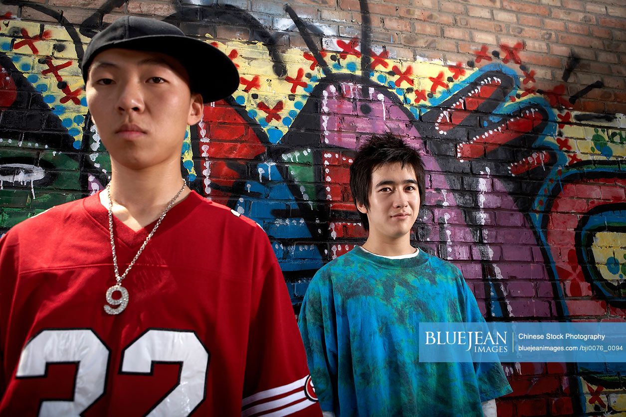 Chinese teenage boys in front of a wall of graffiti