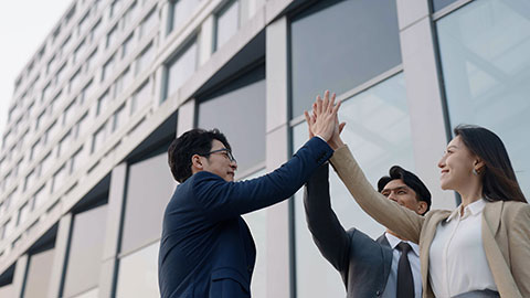 Cheerful Chinese business people celebrating outdoors