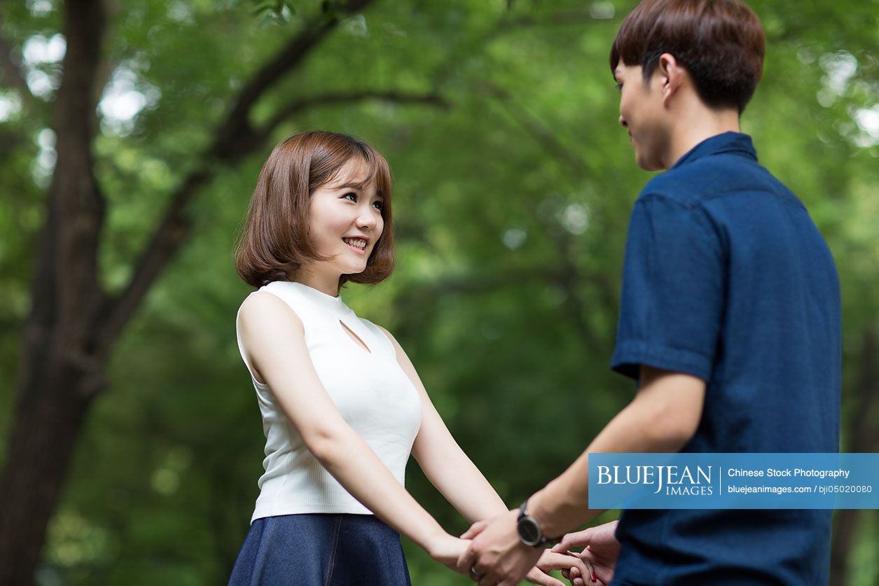 Happy young Chinese couple holding hands