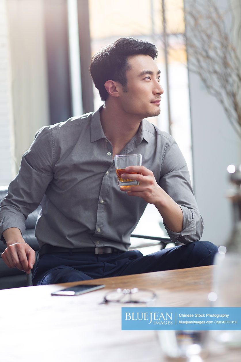 Young Chinese man enjoying fine wine
