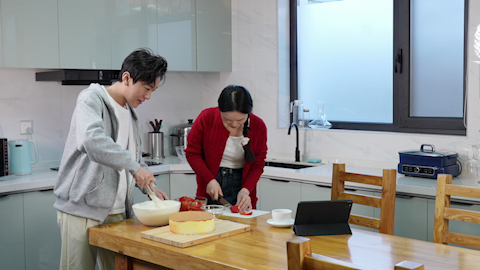 Young couple having fun baking a cake