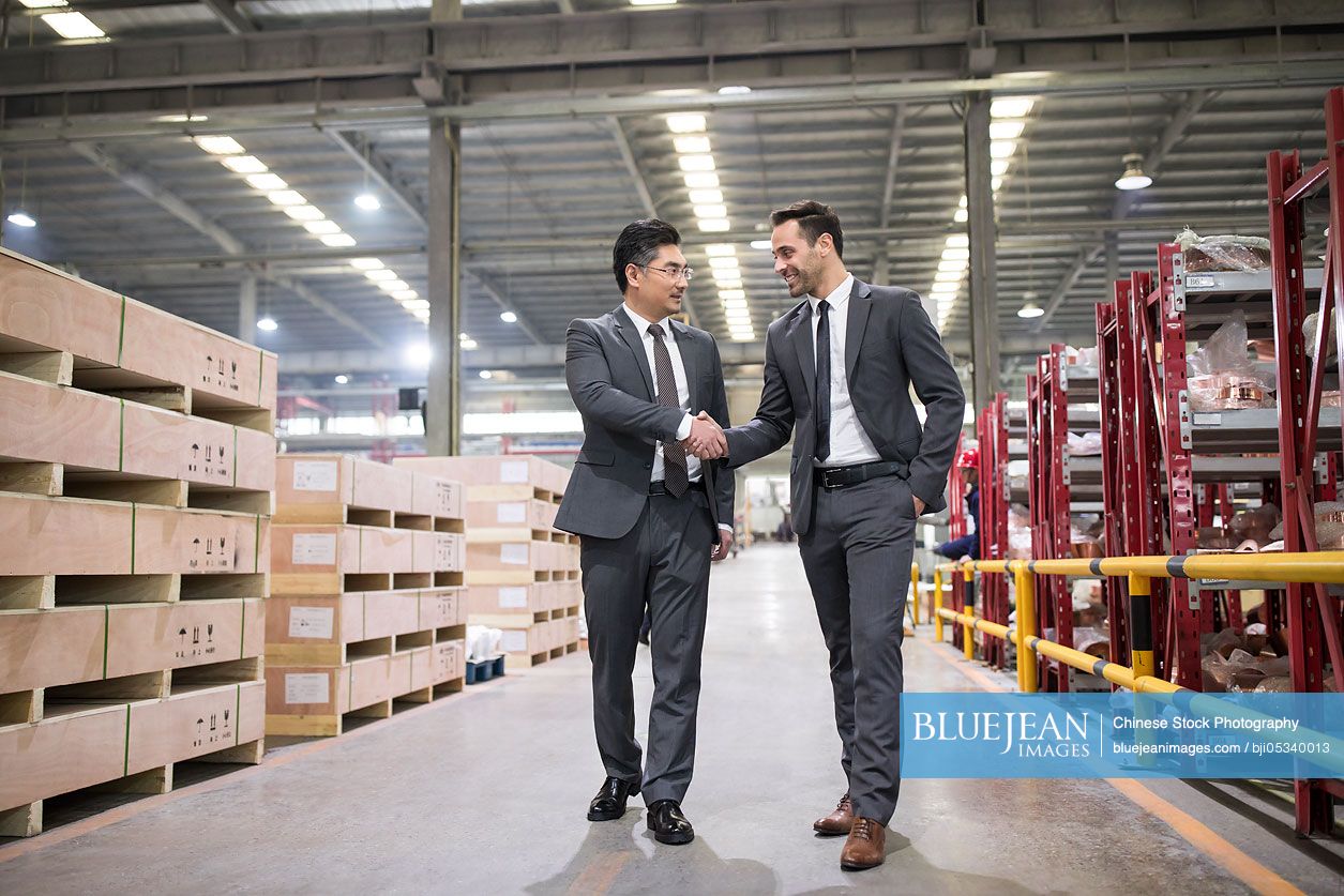 Business people shaking hands in the factory