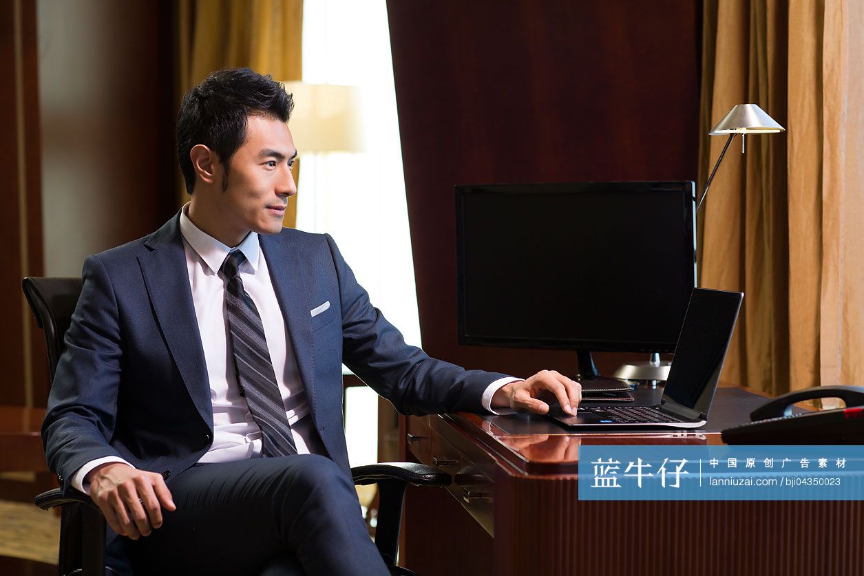 成功商务男士在书房使用笔记本电脑