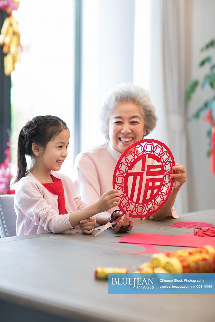 Granddaughter and grandmother with Chinese New Year paper-cut