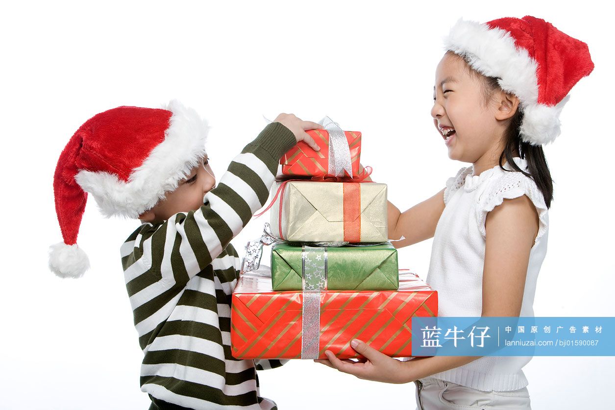 戴着圣诞帽的孩子抱着礼物