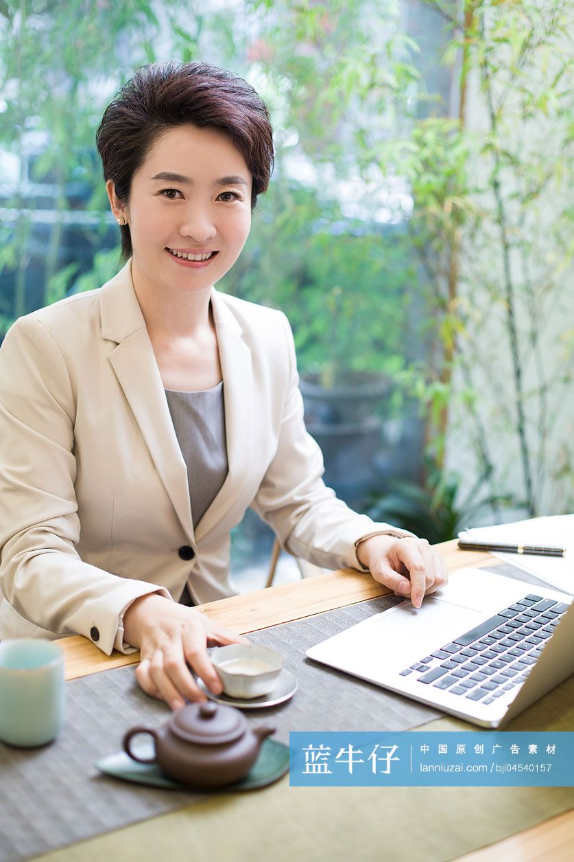 商务女性在茶馆使用笔记本电脑工作