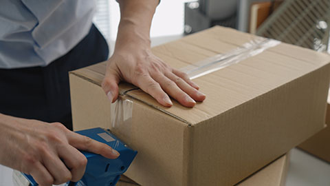 Chinese small business owner packing boxes in office,4K