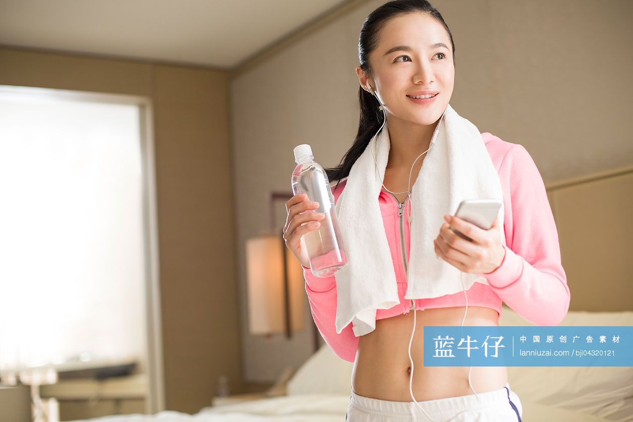 年轻女子在运动结束后听音乐
