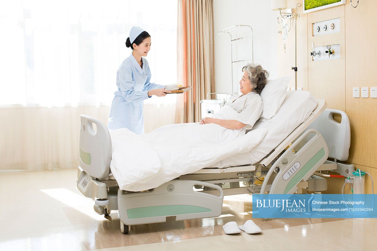 Chinese nurse preparing food for senior patient
