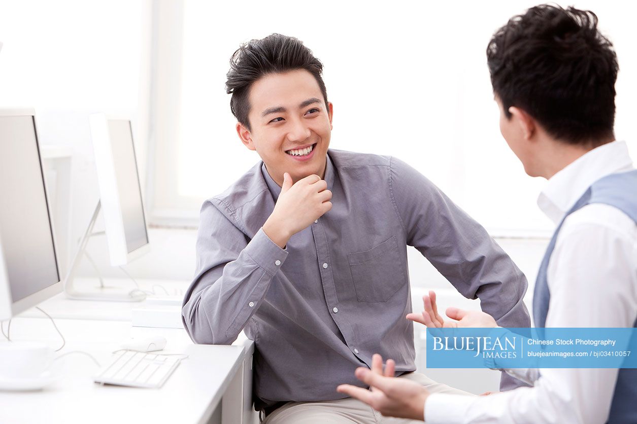Cheerful Chinese business coworkers talking in the office