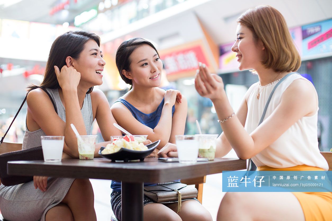 年轻闺蜜在露天咖啡馆聊天