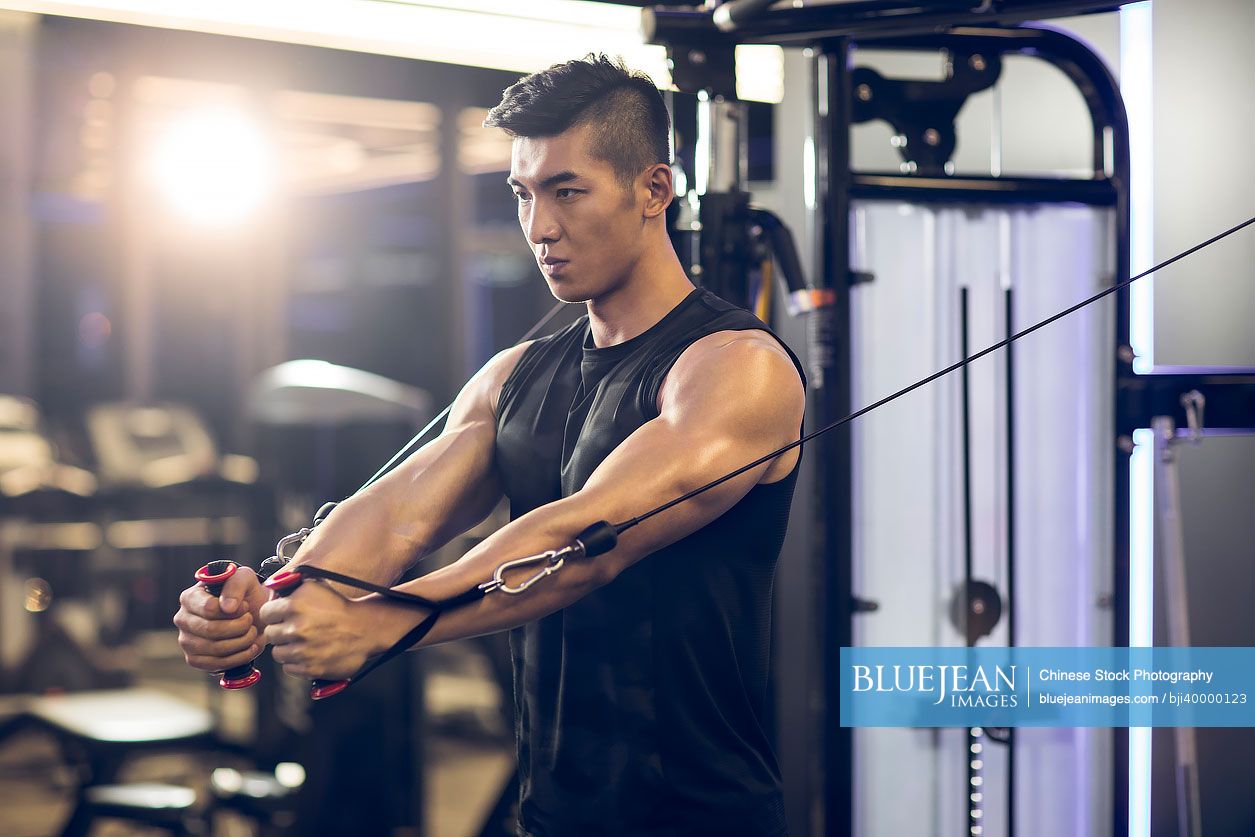 Young Chinese man exercising at gym