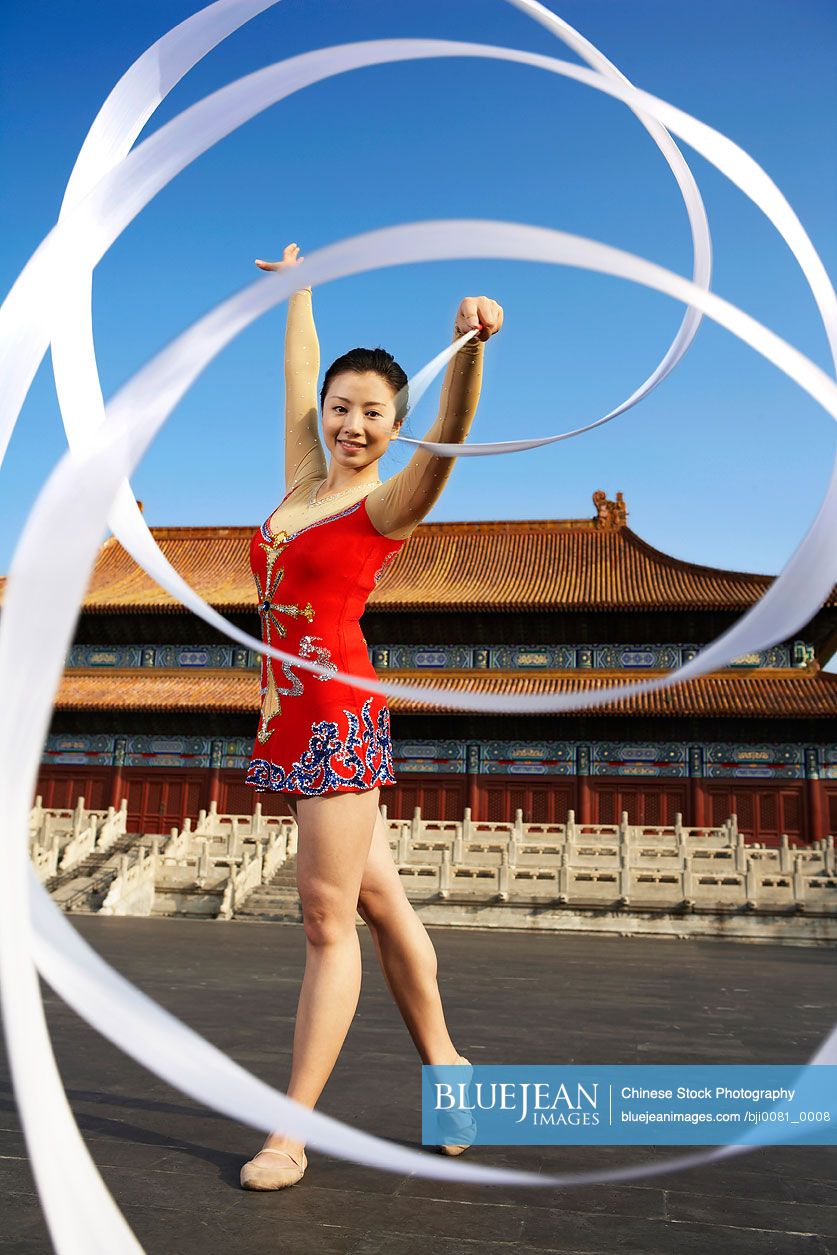 Young Chinese Woman Ribbon Dancing In Front Of A Temple