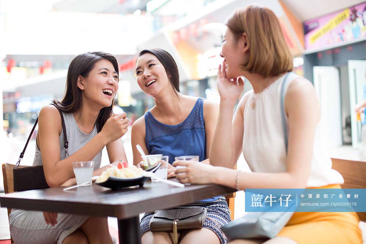 年轻闺蜜在露天咖啡馆聊天