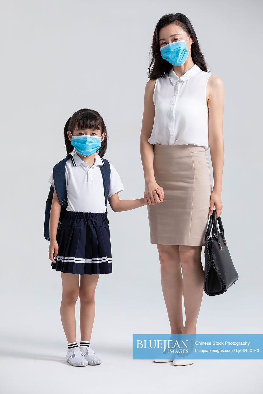 Young Chinese mother and daughter wearing surgical masks