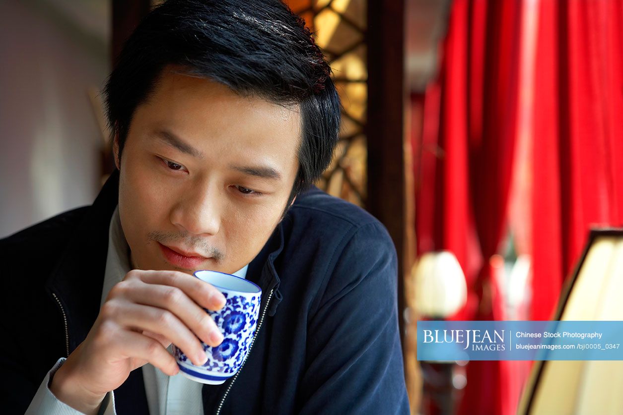 Chinese Man Drinking, Looking Thoughtful