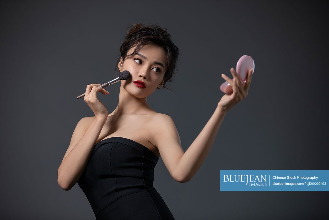 Beautiful young Chinese woman applying makeup-High-res stock photo for  download