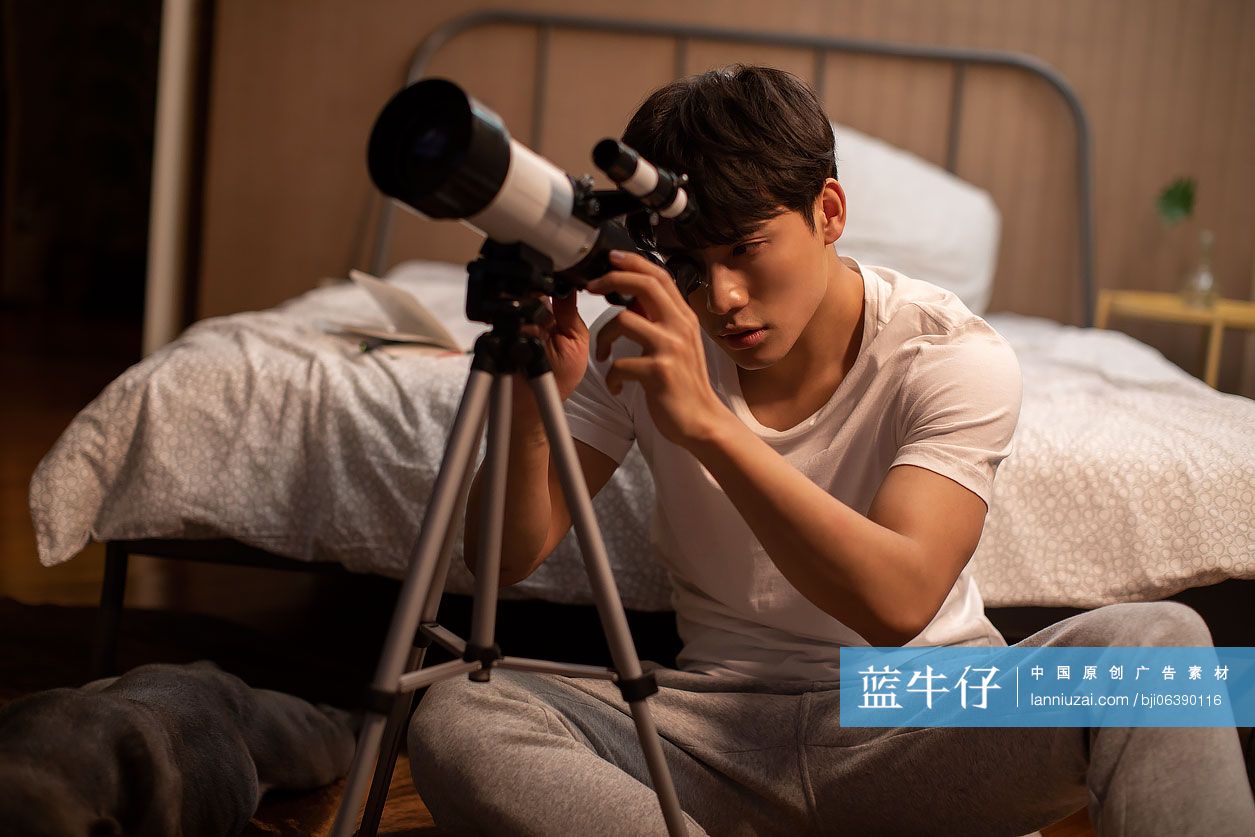 年轻男士在家使用望远镜