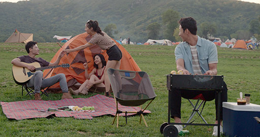 Happy young Chinese friends camping outdoors,4K