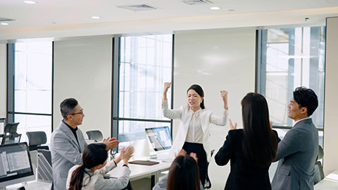 Cheerful Chinese business people applauding in office