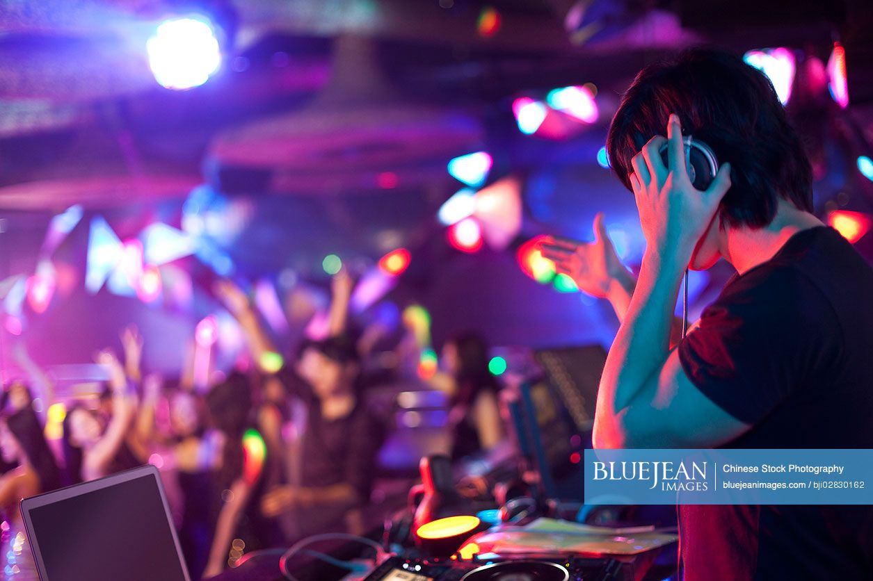 Chinese DJ doing record scratching in nightclub