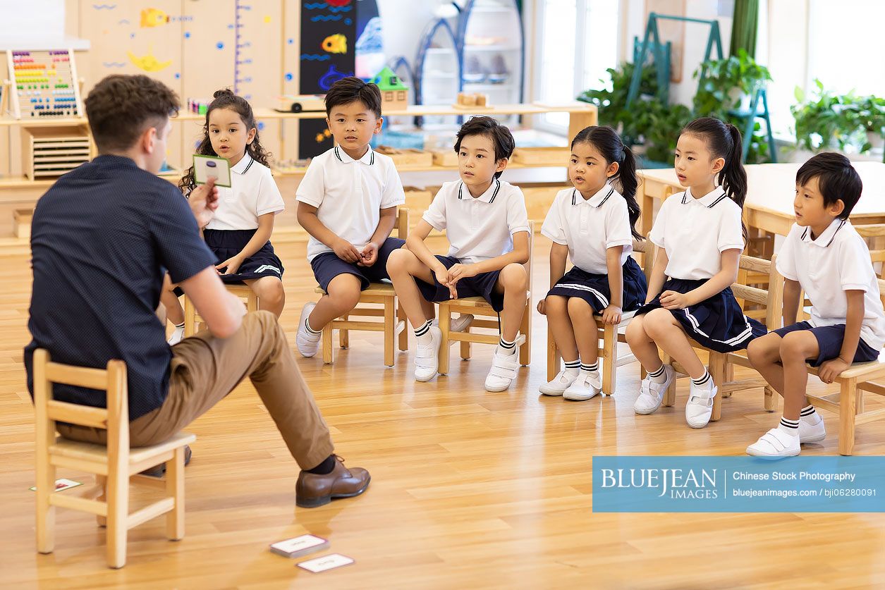 Foreign teacher teaching children English in classroom