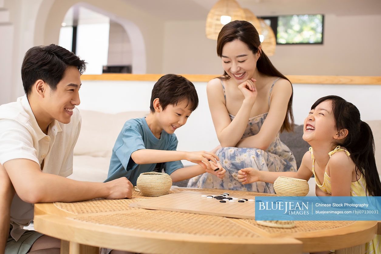 Happy Chinese family playing the game of go
