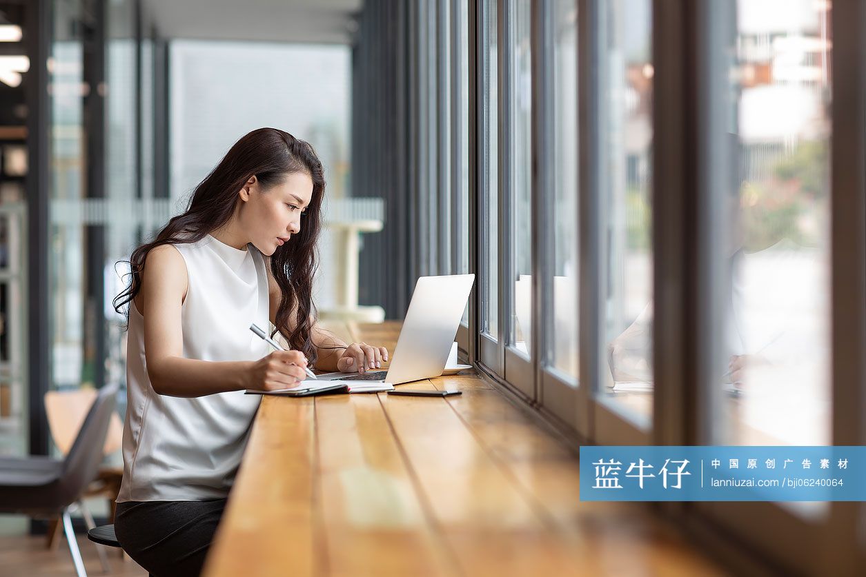 商务女士在咖啡馆使用笔记本电脑工作