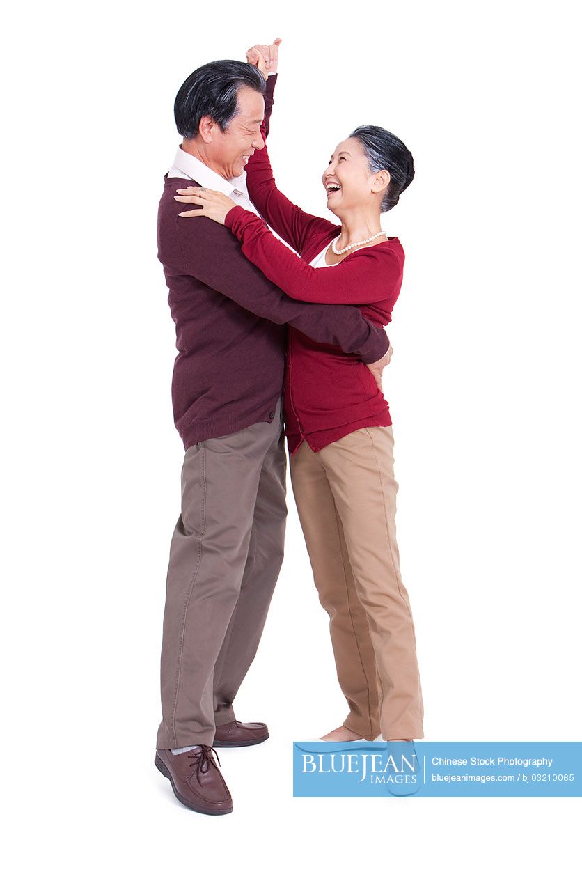 Happy senior Chinese couple dancing, face to face