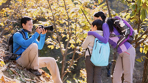 快乐的年轻家庭在树林里拍照