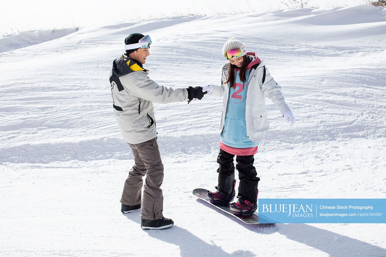 Happy young couple skiing in ski resort